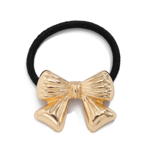 Close-up of golden metallic bow hair tie with fine vertical texture and black elastic cord