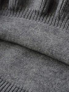 Detailed close-up showing the soft grey knit fabric texture and ribbed edge finish