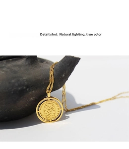 Macro detail shot of vintage gold coin pendant with embossed relief on delicate chain