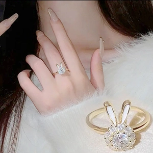 Detail of gold bunny ring with white enamel ears and sparkling cubic zirconia crystals