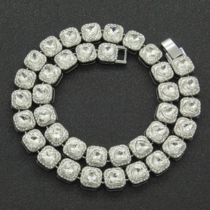 Macro view of silver Cuban chain necklace with heart-shaped rhinestones and pave details