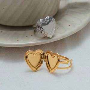 Macro view of a heart-shaped locket ring with vintage floral engraving and openable design