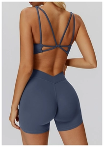 Detail of yoga bra with criss-cross back straps and V-waist shorts in matte navy blue