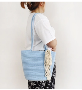 Detailed close-up of light blue woven tote bag with elegant cream lace ribbon decoration
