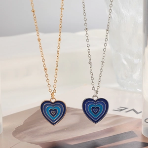 Detailed view of layered blue enamel heart pendants with gold and silver bead chains