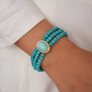 Detail of bohemian turquoise beaded bracelet with gold trim on model wrist