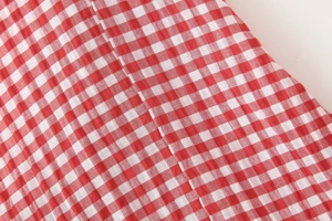 Close-up of red and white gingham fabric texture on a long strap dress material
