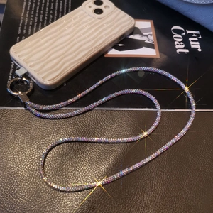 Detailed close-up of premium iridescent rhinestone phone lanyard with silver metal clasp