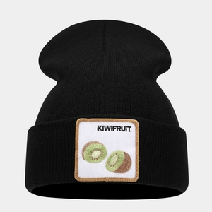 Detail of embroidered kiwi fruit patch on a black knitted beanie with clear texture