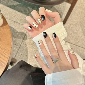 Handmade black and white press-on nails with gold star patterns in short square shape