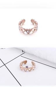 Gros plan détaillé de la bague cœur en or rose avec des accents de zircon brillants