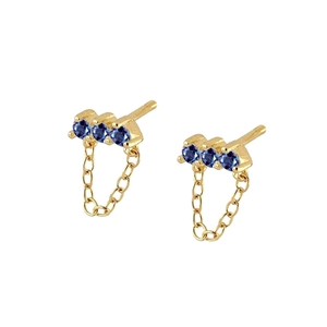 Detail of gold drop earrings featuring three navy blue zircons and a delicate chain dangle
