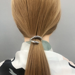 Sleek silver metal ponytail clip with minimalist streamlined design for women's hair