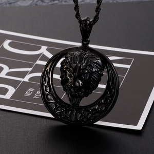 Detail of a matte black stainless steel lion head pendant with textured cable chain