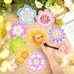 Colorful 54pcs spring flower paper cutouts arranged on a wooden desk with green plants