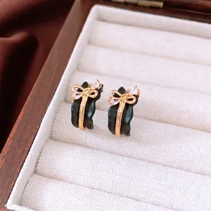 Vintage 18k gold plated black bow earrings with crystals in a luxury wooden jewelry box