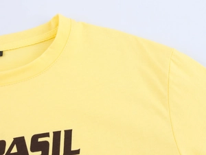 Dettaglio del girocollo e della trama del cotone sulla t-shirt gialla con grafica Brasil