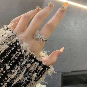 Primo piano di un anello a fiocco in argento con zirconi scintillanti sul dito della modella