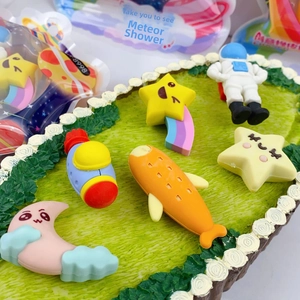 Macro view of astronaut, rocket, and planet shaped puzzle erasers on a green base