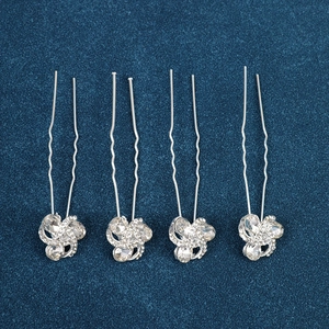 Detail of silver U-shaped hair pins with sparkling rhinestone swirls for bridal hair styling