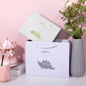 Detailansicht grauer und lila Papiertüten mit niedlichen Cartoon-Dinosaurier-Motiven