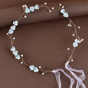 Macro detail of handmade bridal headband with gradient blue flowers and white pearls