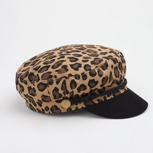 Detail of leopard print baker boy hat with black visor and decorative gold metal buttons