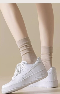 Detail of beige cotton slouch socks with ribbed cuffs shown on model for daily wear