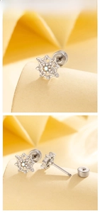 Macro view of star-shaped titanium steel earring with opal center and screw back detail