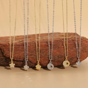 Elegant gold and silver necklaces with flower and moon pendants on a wooden stand