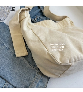 Detail of soft beige canvas fabric and adjustable wide strap on the crossbody bag