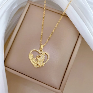 Detail of gold heart pendant with butterfly and floral motifs on a gift box