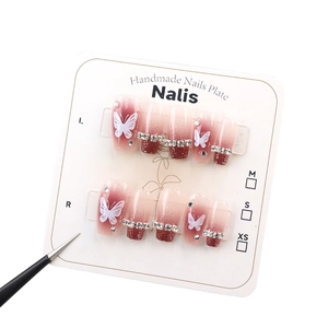 Handmade cherry gradient press-on nails with white butterfly patterns and sparkling rhinestones