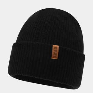 Close-up of black ribbed knit beanie with premium brown leather logo patch detail