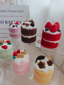 Detailed top view of six colorful mini cake-shaped scented candles with realistic toppings