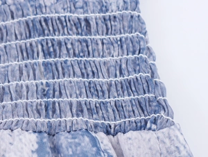 Détail de la robe en mousseline tie-dye bleu avec des coutures élastiques froncées