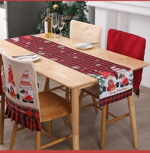 Close-up of Christmas gnome table runner and chair cover set on a rustic wooden table