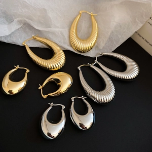 Detailed shot of assorted gold and silver drop earrings with smooth and ribbed finishes