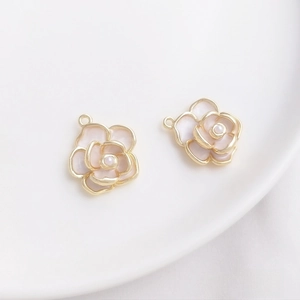 Detailed close-up of two pink enamel camellia flower charms with small center pearls