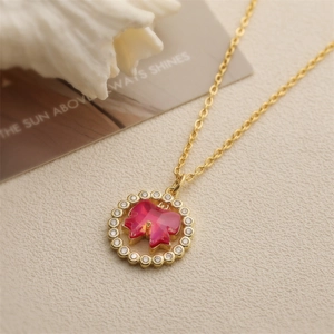 Gold pendant necklace with circular micro-paved crystal ring and red bow center stone