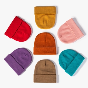 Set of seven colorful ribbed knit beanies in a circular flat lay display for autumn winter