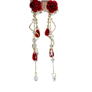 Vintage style red velvet rose earrings with gold tassels and pearl accents on white background
