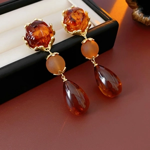 Detailed view of vintage gold flower earrings with amber beads and teardrop pendants