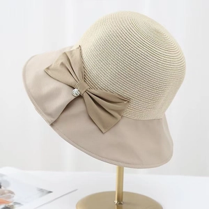 Detail view of the elegant bow decoration on a summer patchwork straw sun hat