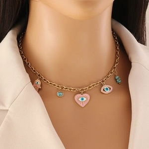 Collier en acier doré avec pendentifs main et cœur œil maléfique rose sur un mannequin