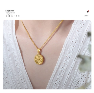 Close-up of a vintage round lotus flower embossed pendant on a gold titanium chain