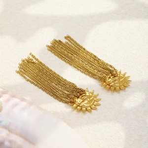 Detail of gold sun and moon face earrings with delicate long chain fringe tassels