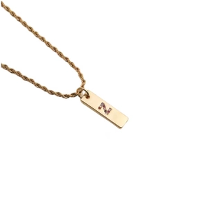 Close-up of golden rope chain and rectangle pendant featuring multi-colored zircon letter Z