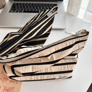 Close-up of striped cosmetic bags with durable fabric texture and secure metal zippers