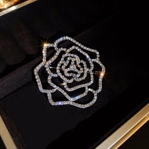 Macro shot of silver hollow rose brooch with sparkling crystals in a black velvet jewelry box